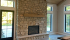 floor to ceiling stone fireplace with timber mantle