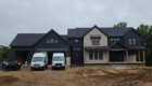 New home with black siding and stone accents