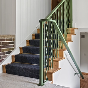 staircase with custom green railing